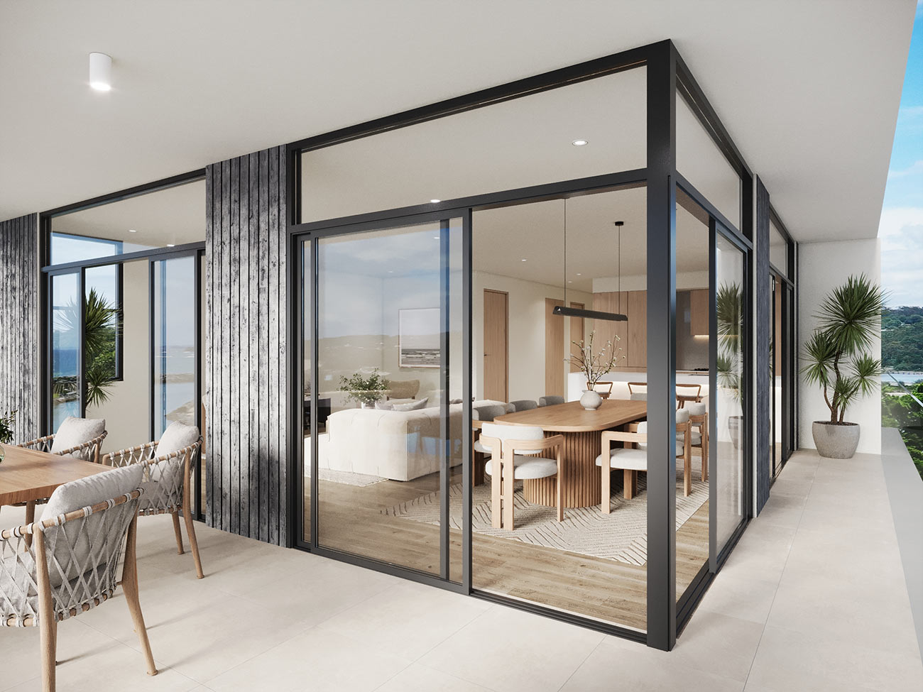 Modern apartment balcony with outdoor living setup and coastal outlook