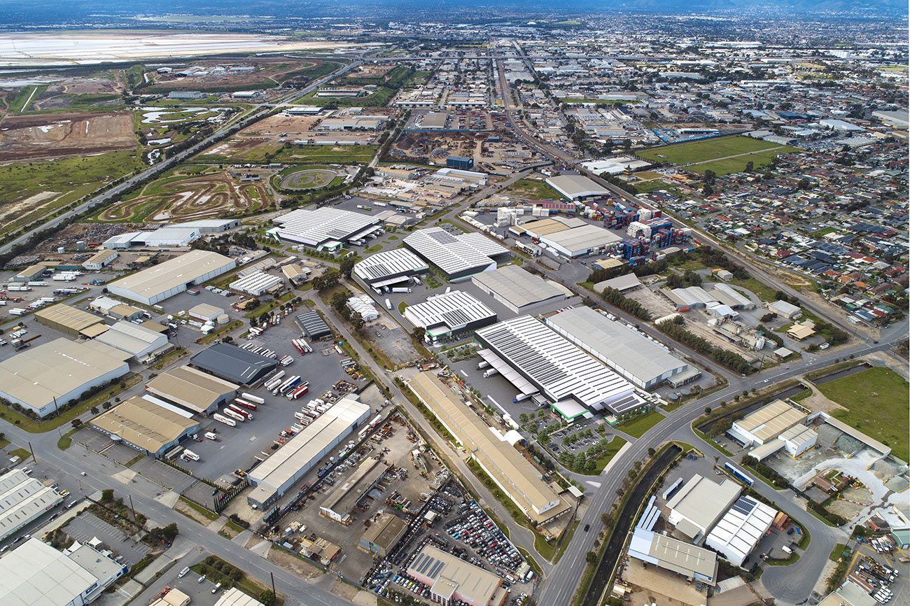 3D Render photomontage aerial view of industrial warehouse development with logistics facilities roads parking and surrounding urban infrastructure