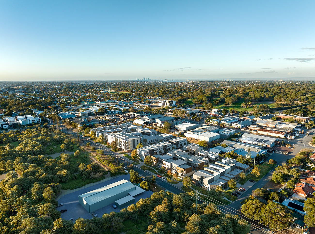 3D Render photomontage aerial view of suburban housing development with modern townhouses surrounding streets greenery and urban infill neighborhood context